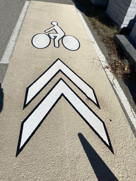 Symboles PREMARK™ contrastés Homme à vélo et chevrons sur piste cyclable en Spraygrip RAL 1015